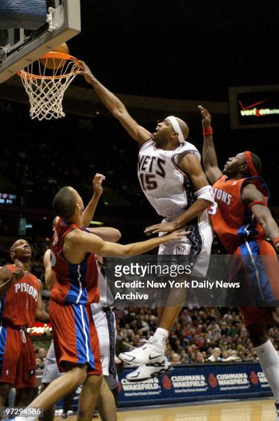 New Jersey Nets' Vince Carter dunks against Detroit Pistons' Tayshaun Prince and Ben Wallace in the first half at Continental Airlines Arena. The...