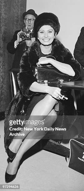 Sophia Loren brightens International Airport after arrival from Paris. She was honored as best actress at New York Film Critics Circle annual awards...