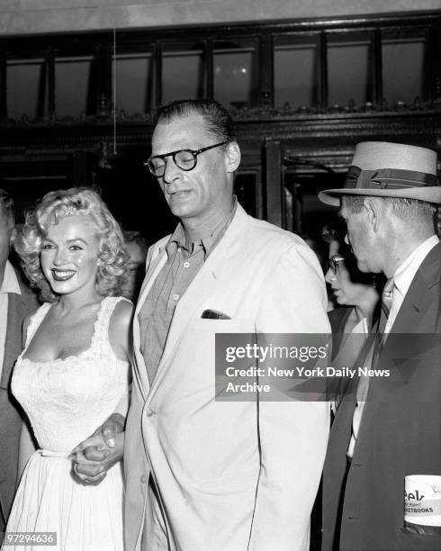 Marilyn Monroe and her husband, Arthur Miller, smile as she leaves Doctors Hospital. But Marilyn was reported exhausted after losing her child, which...