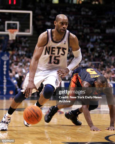 New Jersey Nets' Vince Carter gets the ball around Golden State Warriors' Baron Davis during the fourth quarter of a game at Continental Airlines...
