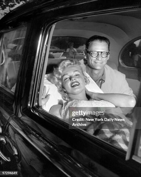 Marilyn Monroe and her husband, Arthur Miller, smile as she leaves Doctors Hospital. But Marilyn was reported exhausted after losing her child, which...