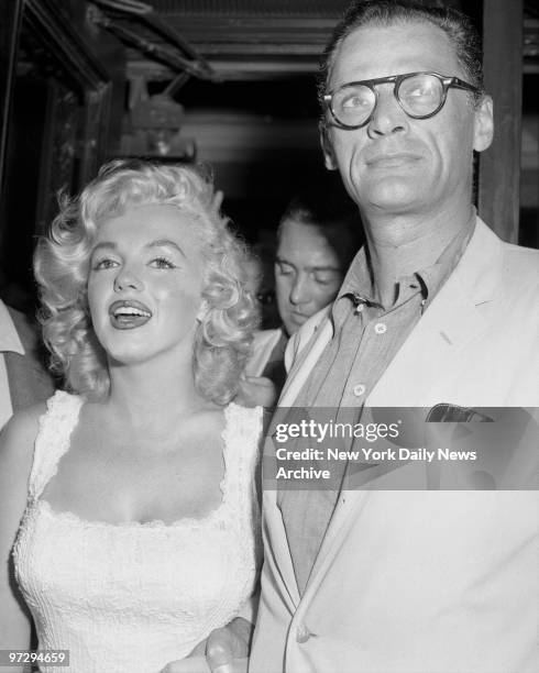 Marilyn Monroe and her husband, Arthur Miller, smile as she leaves Doctors Hospital. But Marilyn was reported exhausted after losing her child, which...