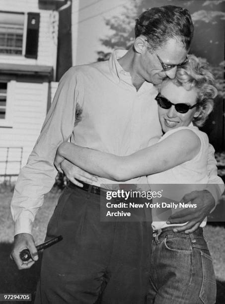 Marilyn Monroe hugs her fiance, Arthur Miller, on the lawn of Miller's home.