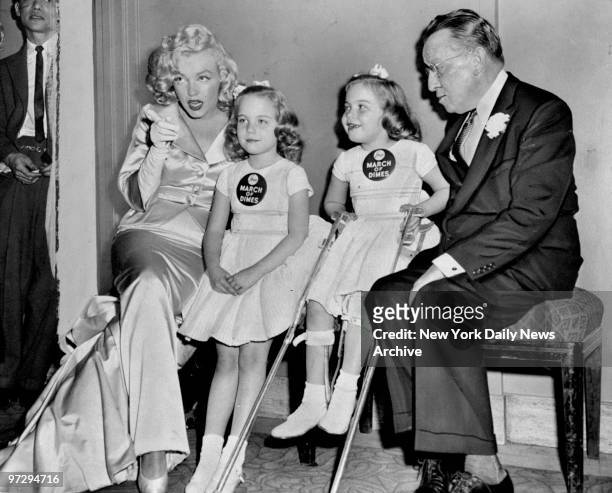 Marilyn Monroe with March of Dimes poster children, Linda Lou and Sandy Sue, and Basil O'Connor of the Polio Foundation at the 14th Annual March of...