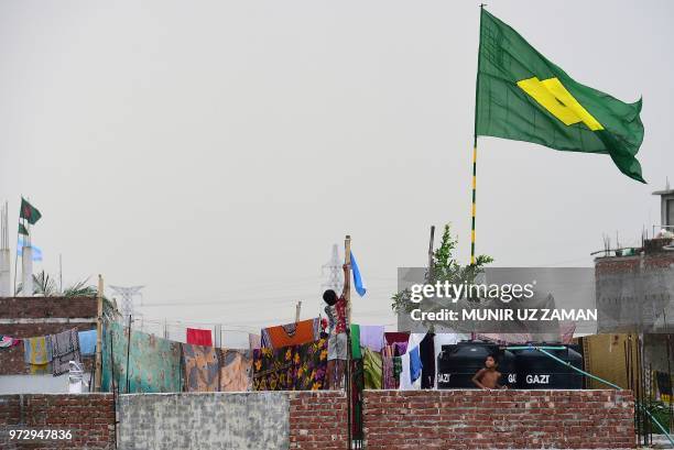 This photograph taken on June 6, 2018 shows a child hoisting the national flag of Argentina on the outskirts of Dhaka. - The World Cup has become a...