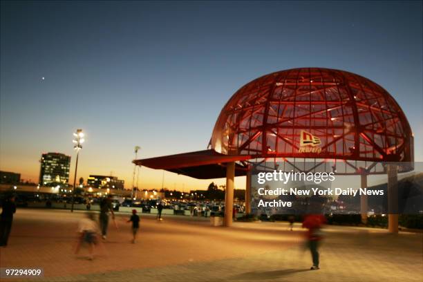 The sun sets beyond a giant Los Angeles Angels baseball cap outside Angel Stadium on the night before the start of the American League Division...
