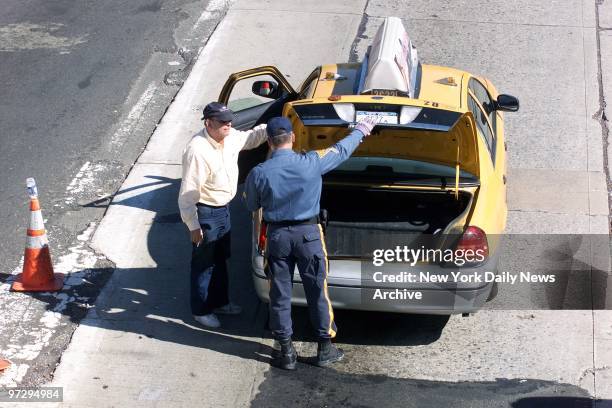 New Jersey State Police officer inspects a taxi on the New Jersey side of the Lincoln Tunnel, where traffic was backed up for two to three hours as...