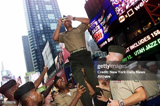 Marines give fellow one of their mates a boost so he can snap a photograph of R&B singer Mya as she entertains at "NYC 200 Salutes the American...