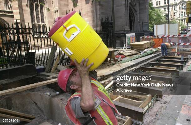 Mario Persichillo lifts a tall cool drink on a swiltering day before going on with his work on the rehabilitation of the Rector St. Subway station....