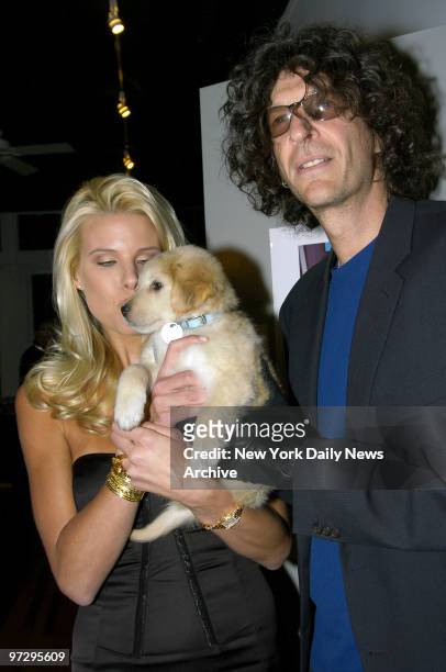 Shock jock Howard Stern and girlfriend Beth Ostrosky hold Marcus, a puppy that is up for adoption at the North Shore Animal League America, during a...