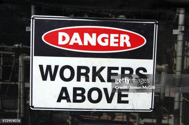 'danger: workers above' sign on a fence around a construction site - hazardous area sign stock pictures, royalty-free photos & images