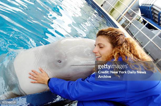 New York Aquarium trainer Joanne Sottile gets a kiss from Marina, one of three female beluga whales who will be on their way to Georgia next month....