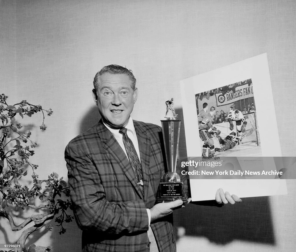 Daily News photographer Charles Hoff holding hockey award tr