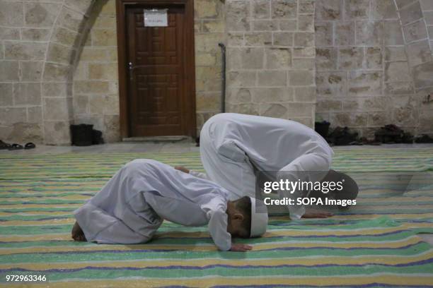Muslim kid seen performing the night prayer next to his dad. Palestinian worshippers attend a night prayer during Laylat Al-Qadr, on the 27th day of...