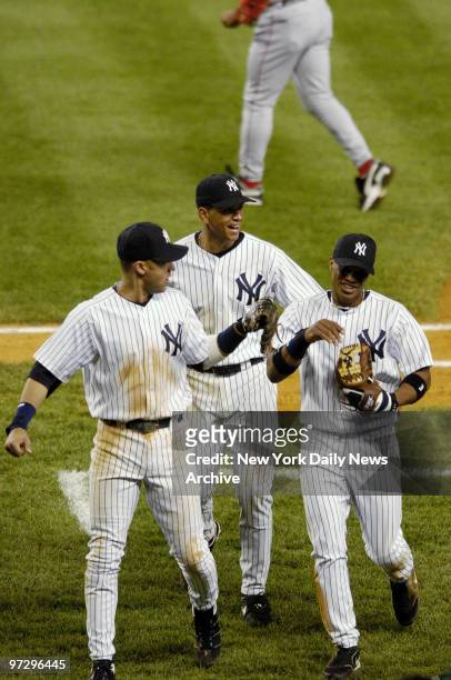 New York Yankees' infielder Robinson Cano is congratulated by shortstop Derek Jeter and third baseman Alex Rodriguez after the top of the sixth...