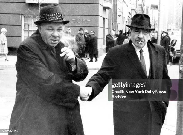 Frank Costello is greeted by an unidentified friend on 1st and Madison Avenue as he left Frank Campbell Funeral Home for funeral services for Frank...