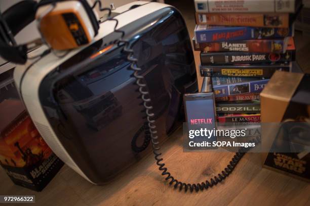 In this photo illustration, the Netflix application seen displayed on an Android Sony smartphone surrounded by old videotapes.