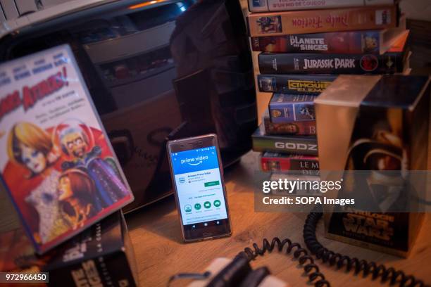 In this photo illustration, the Amazon Prime Video application seen displayed on an Android Sony smartphone surrounded by old videotapes.