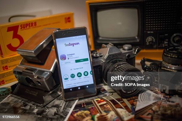 In this photo illustration, the Instagram application seen displayed on an Android Sony smartphone surrounded by vintage cameras.