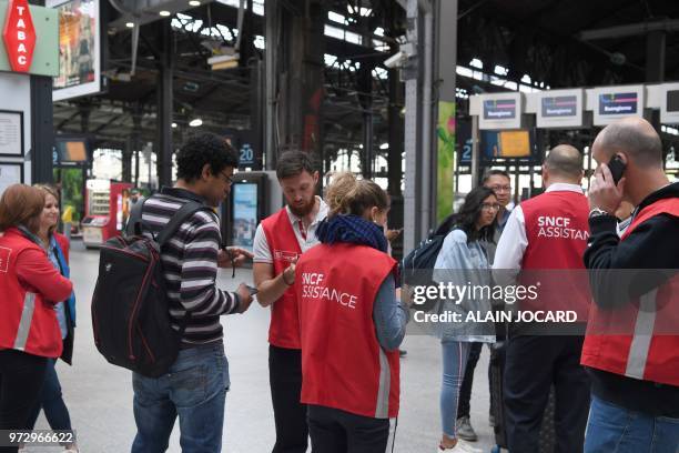 Employee give assistance to commuters on June 13, 2018 at Paris' gare Saint-Lazare train station as the traffic is completely interrupted due to a...