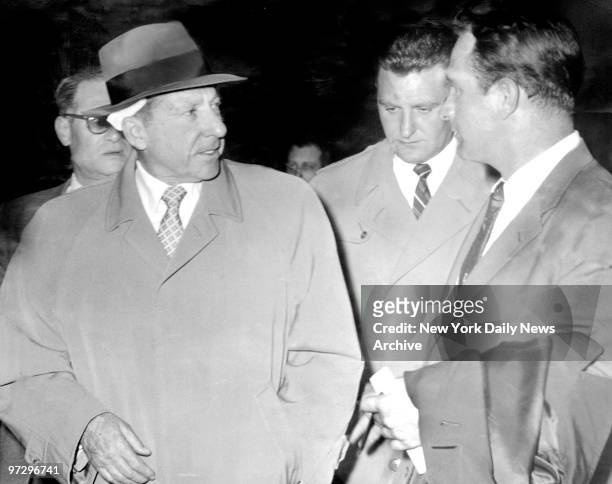 Frank Costello, wearing bandage over his scalp wound, talks to reporters at police station on West 43th Street. Scores of detectives were assigned to...