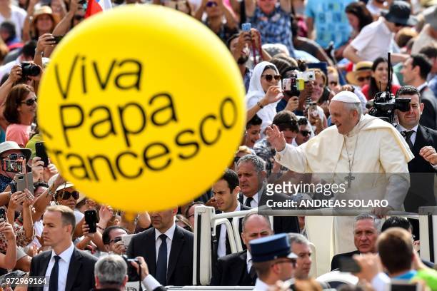 Pope Francis waves to faithful as he arrives for his weekly general audience at Saint Peter's square on June 13, 2018 in Vatican.
