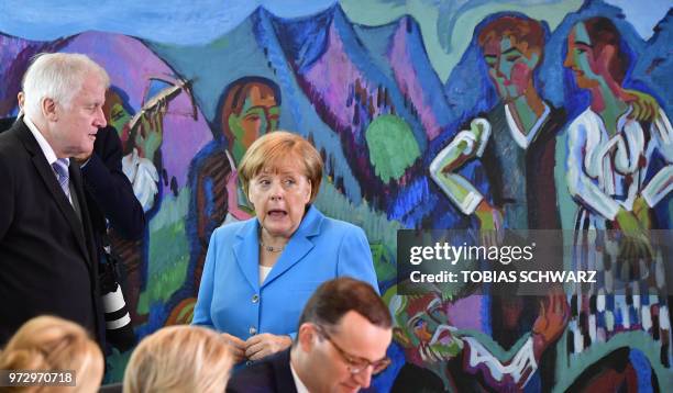 German Chancellor Angela Merkel talks with Interior Minister Horst Seehofer prior to the weekly cabinet meeting in Berlin on June 13, 2018.
