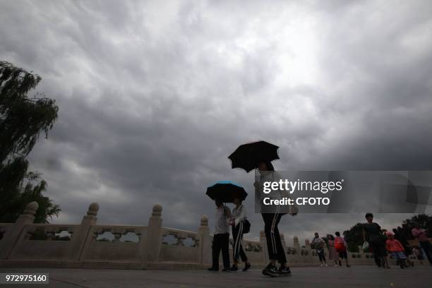 At noon on June 13 Beijing beihai park, China,a large cloud of rain and rain hung over the capital.