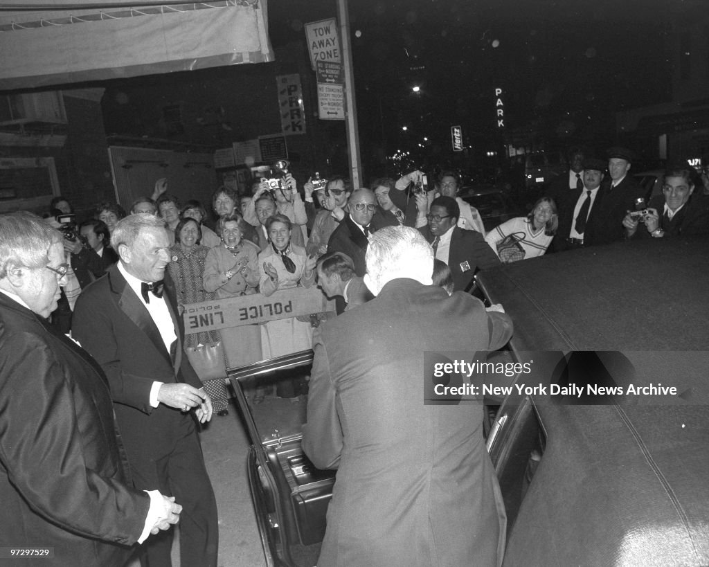 Frank Sinatra is cheered by adoring lady fans and clicking p