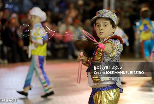 Young dancers blows soap bubbles during the Santo Antonio de Lisboa's Parade on Avenida da Liberdade, in Lisbon on June 12, 2018. - Lisbon celebrates...