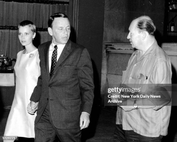 Frank Sinatra talks to a fan as he and wife Mia Farrow leave 21 Club.