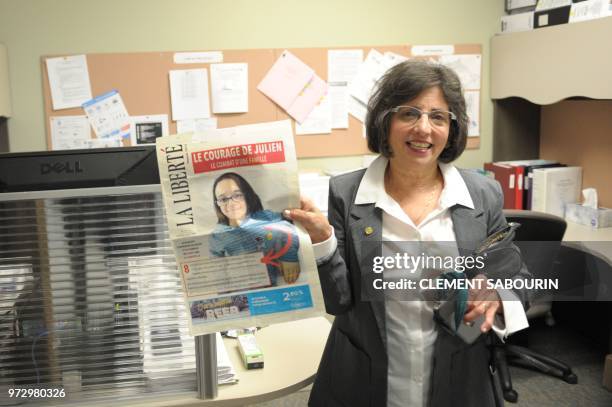 Dr Cheryl Greenberg, a Canadian genetic researcher, shows the front page of a local Canadian newspaper with the face of young Frenchman Julien...