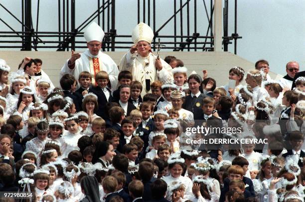 Pope John Paul II is surrounded by children 13 June 1987 in Lodz as he celebrates a mass during his visit to Poland. AFP PHOTO DERRICK CEYRAC