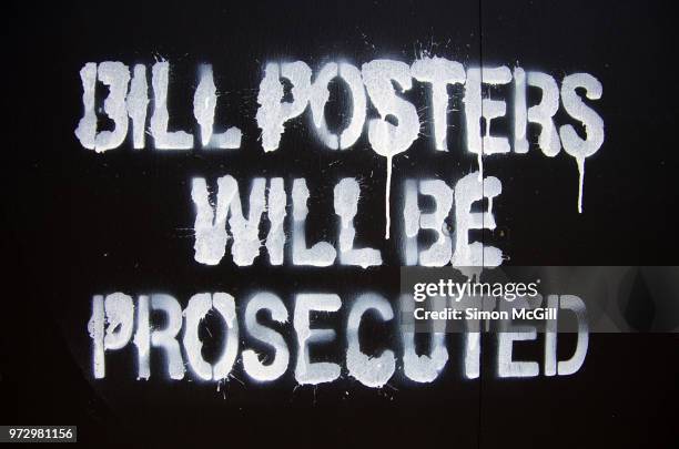 'bill posters will be prosecuted' sign spray-painted on a construction hoarding - stencil stock pictures, royalty-free photos & images