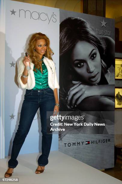 Singer Beyonce Knowles holds up a bottle of True Star perfume, part of a fragrance collection she created in partnership with Tommy Hilfiger...