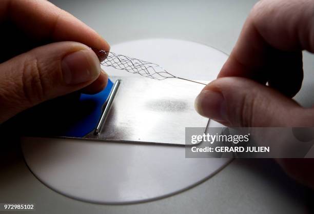 Technician shapes a stent "Catch" in the production unit of stents and catheters of the BALT company in Montmorency, on June 7, 2018. Since it was...