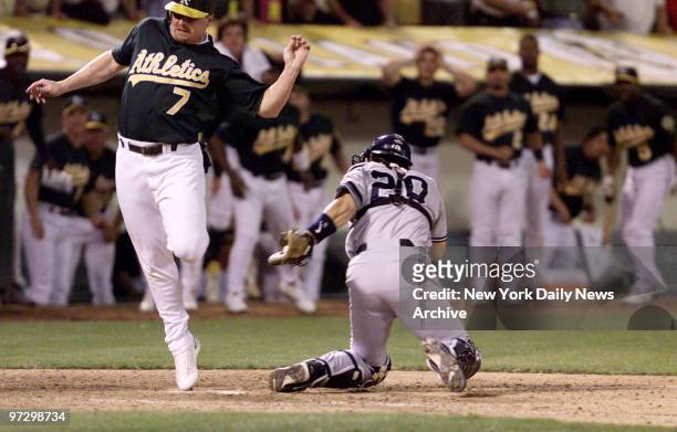New York Yankees' Jorge Posada holds on to ball after sweep tag on Oakland Athletics' Jeremy Giambi during Game 3 of American League Division Series....