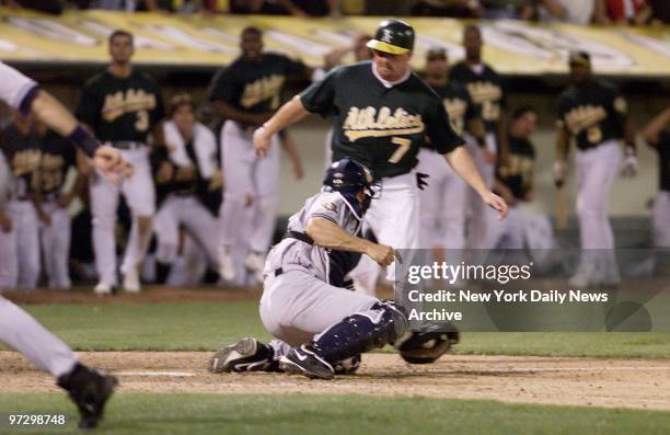 New York Yankees' Jorge Posada holds on to ball after sweep tag on Oakland Athletics' Jeremy Giambi during Game 3 of American League Division Series....