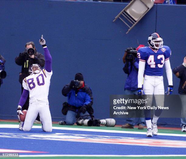 Things are looking up for Minnesota Vikings' Chris Carter after he caught touchdown pass. At right, New York Giants' Percy Ellsworth heads back to...