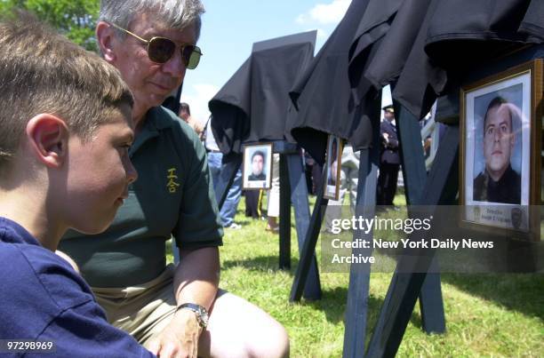 Jimmy Vigiano is joined by grandfather John Vigiano as he examines a photograph of his father, Det. Joseph Vigiano, which hangs beneath a plaque...