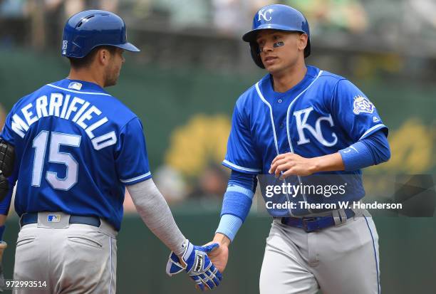 Ryan Goins of the Kansas City Royals is congratulated by Whit Merrifield after Goins scored against the Oakland Athletics in the top of the second...