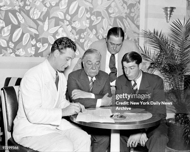 New York Yankees' Lou Gehrig signs contract to take $36, 750 while Jake Ruppert, Joe McCarthy and Joe DiMaggio look on.