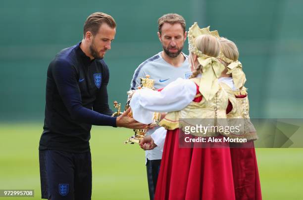 Gareth Southgate, Manager of England and Harry Kane of England a presented with gifts during a training session as part of the England media access...