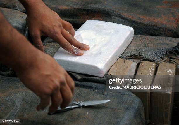 Colombian policeman shows a package of cocaine after a 7.5-ton seizure on June 14 in Tumaco, Narino department, Colombia. According to the...