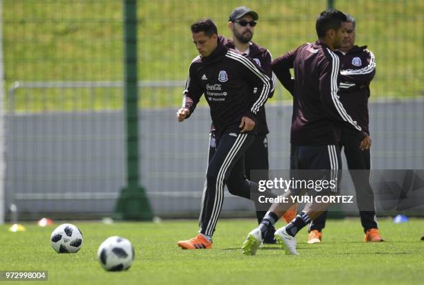 Mexico's national team forward Javier Hernandez runs next to teammate midfielder Jesus Corona during a training session at the Novogorsk training...