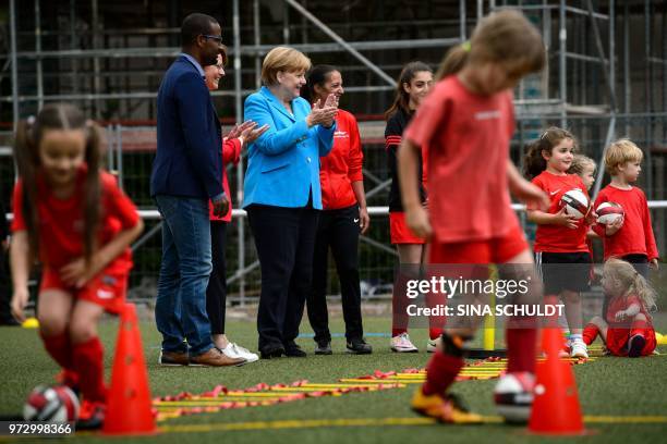 German Chancellor Angela Merkel applauds children taking part in the event "Sports and Integration" as she visits the "SV Rot-Weiß Viktoria Mitte 08"...