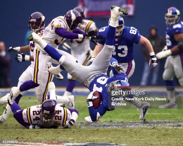 New York Giants' Amani Toomer is upended but hangs onto the ball after receiving pass in play against the Minnesota Vikings in the NFC Championship...