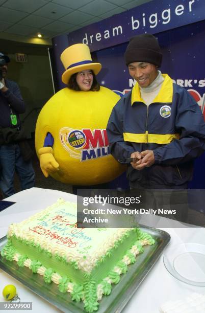 Central Park landscaper Phin Suy, joined by the Megaball mascot, prepares to cut a cake at Madison Square Garden celebrating his $128 million Mega...