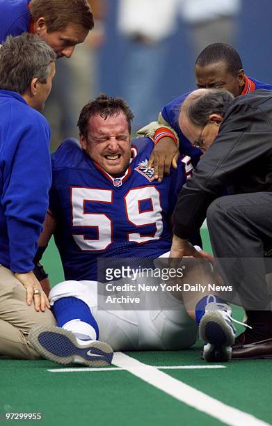 New York Giants' Brian Williams grimaces in pain after going down in first half of game against the New York Jets at the Meadowlands.