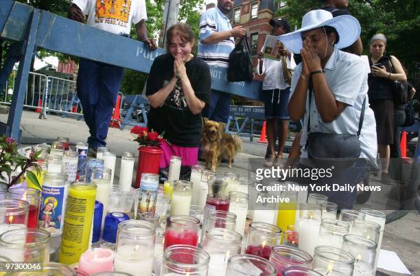 JoAnn Antista and Carolyn Caston pray at a makeshift memorial outside the office of Councilman James Davis on DeKalb Ave. In Brooklyn. Davis was shot...
